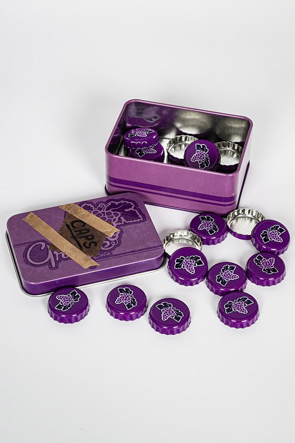 Geopend Fallout Nuka Grape verzamelblik met de bottle caps erin en ernaast