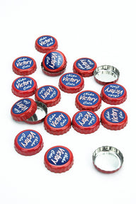 De 20 losse Fallout Nuka Victory bottle caps uitgespreid